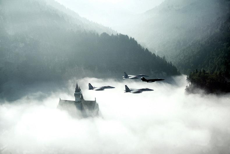 four fighter jets flying over castle