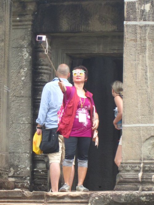 woman taking photo of herself with camera on a stick The Friday Shirk Report   November 12, 2010 | Volume 83