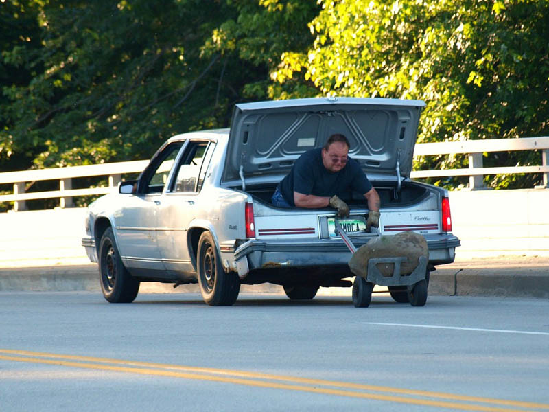 man sitting in trunk of car using dolly to move big The Friday Shirk Report   Volume 117