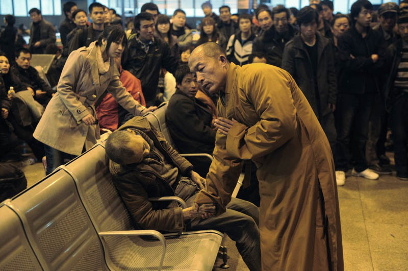 monk prays for dead person in airport china Picture of the Day: A Prayer for the Dead