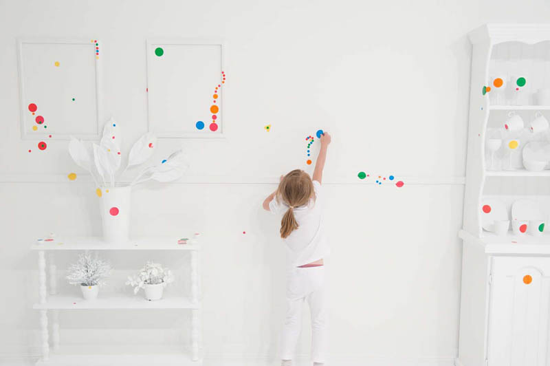 white room covered in stickers by kids yayoi kusama obliteration room 4 Kids Turn White Room into Explosion of Color