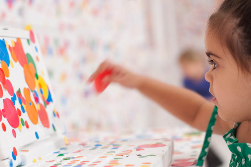 white room covered in stickers by kids yayoi kusama obliteration room 7 Kids Turn White Room into Explosion of Color