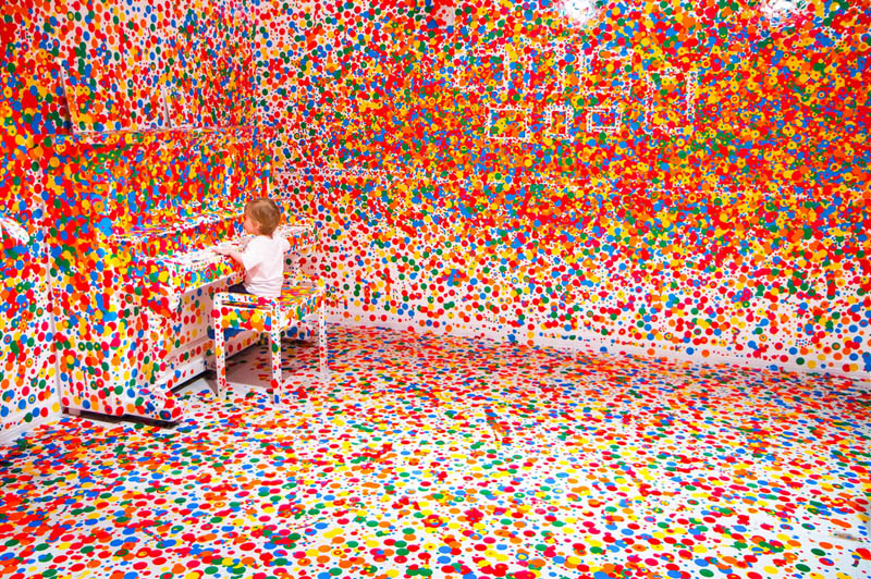 white room covered in stickers by kids yayoi kusama obliteration room 9 Kids Turn White Room into Explosion of Color