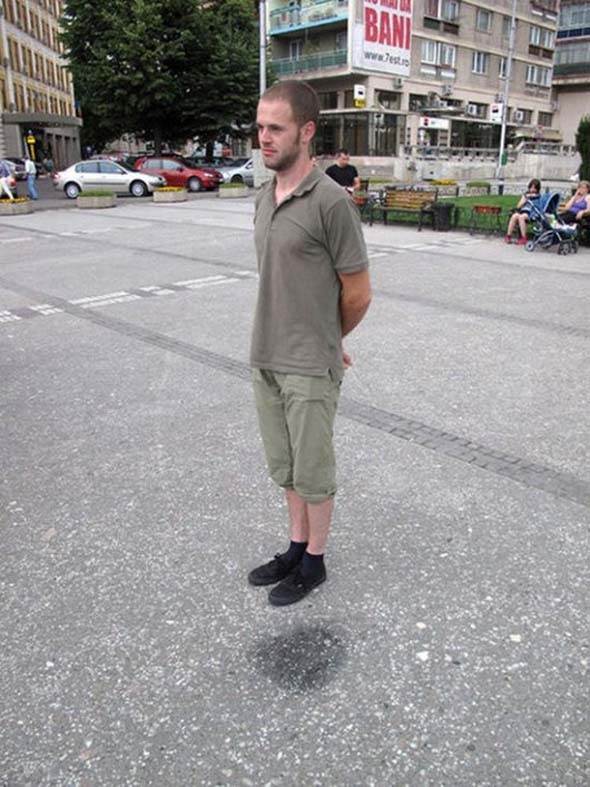 standing beside dark spot on ground hovering 12 Optical Illusions Made from Shadows