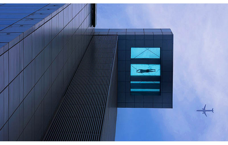 view from below looking up at the 24th floor glass bottomed pool that overhangs the street at the holiday inn in shanghai china