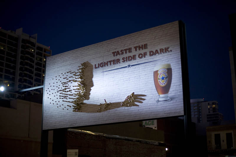 beer billboard using light to create shadow of person reaching for a beer