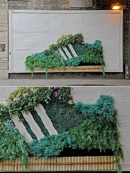 adidas billboard with plants growing on it