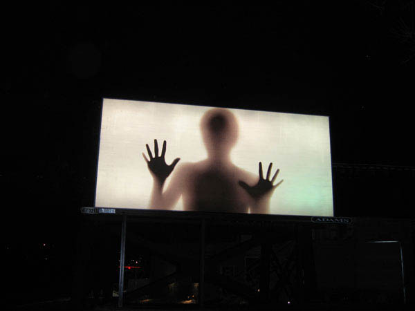 ad shows silhouette of person alien creepy behind foggy glass