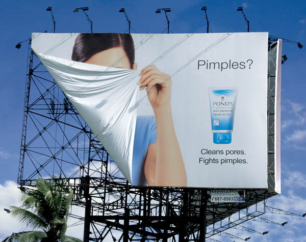 ponds billboard shows woman hiding face with part of billboard because of pimples