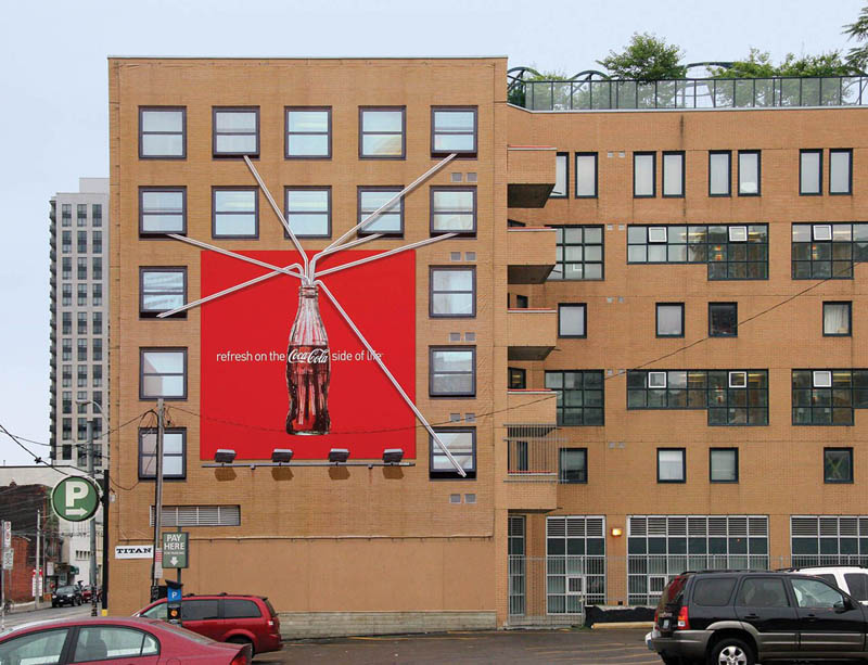 coca cola billboard shows apartments with straws into large coke bottle
