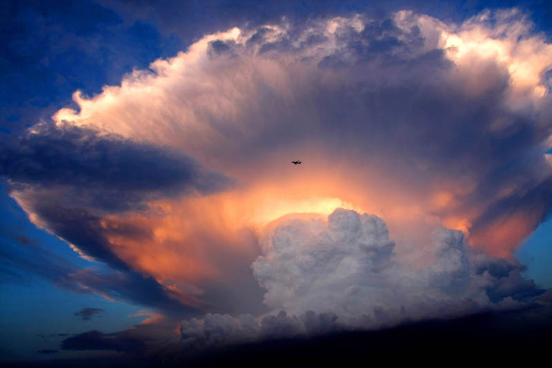 huge mushroom storm cloud cumulonimbus over beijing with plane flying past