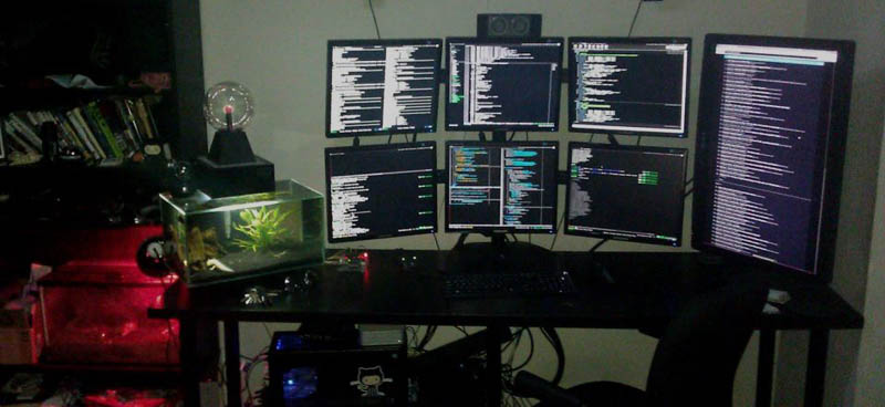 seven monitor setup with two rows of three stacked and one monitor portrait style to the side