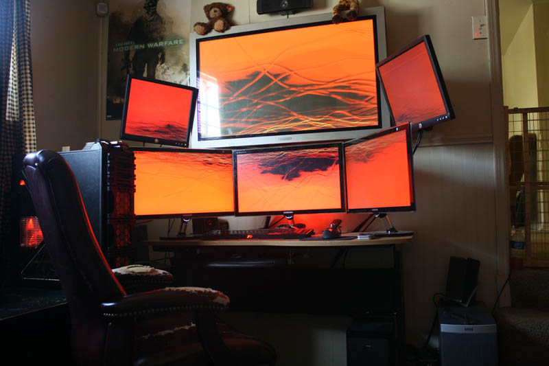computer station setup with six monitors three on bottom three on top