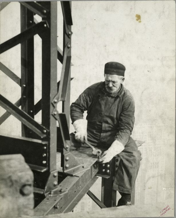 worker attaching bolt to beam no harness sitting on edge at top of empire state building 1931