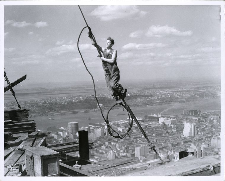 high up on a wire building the empire state building 1931 new york city visible in background