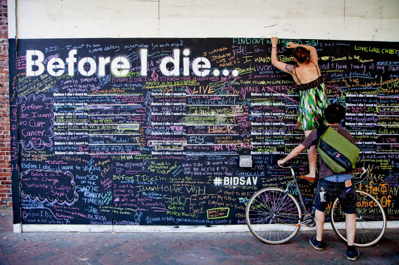 standing on a bike to reach top of before i die footprint to write her submission