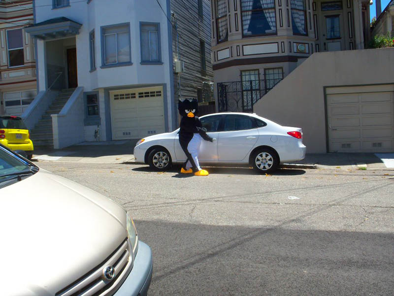 guy in angry bird costume getting into his car staring at person across street taking a picture
