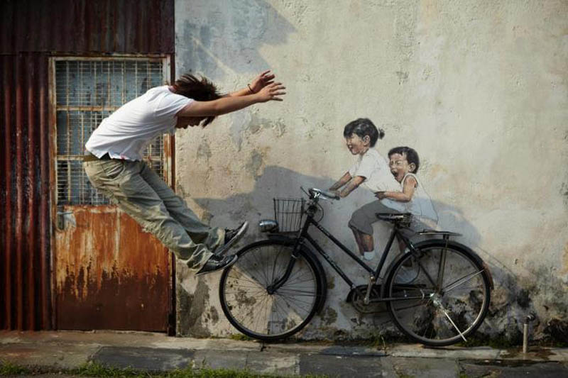intearctive street art painted kids on wall riding real bike armenian street george town malaysia ernest zacharevic 2 This Interactive Street Art in Malaysia is Brilliant