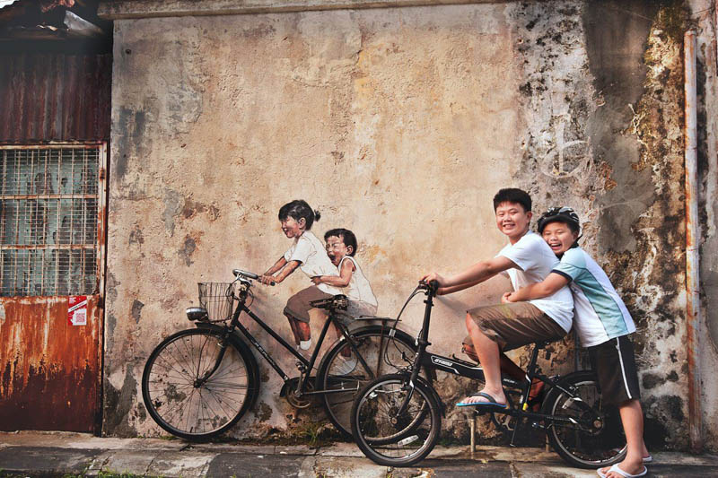 interactive street art painted kids on wall riding real bike armenian street george town malaysia ernest zacharevic 1 This Interactive Street Art in Malaysia is Brilliant