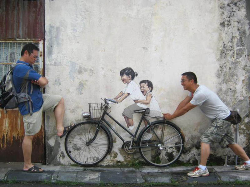interactive street art painted kids on wall riding real bike armenian street george town malaysia ernest zacharevic 4 This Interactive Street Art in Malaysia is Brilliant