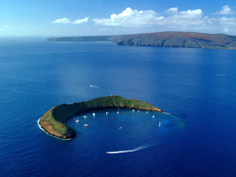 sail boats inside the crescent shaped crater of Molokini in Maui, Hawaii
