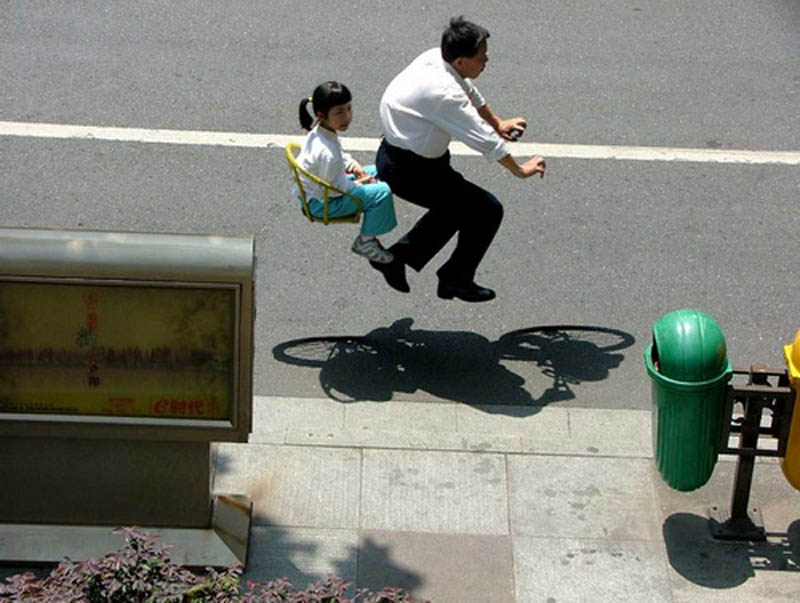 father and daughter riding invisible bike look like they are flying