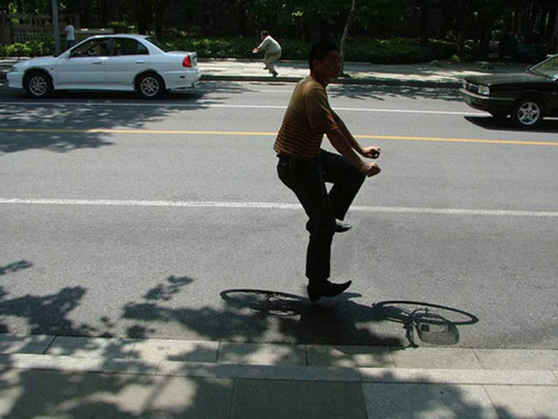 portrait of person riding an invisible bike with shadow of bike still visible