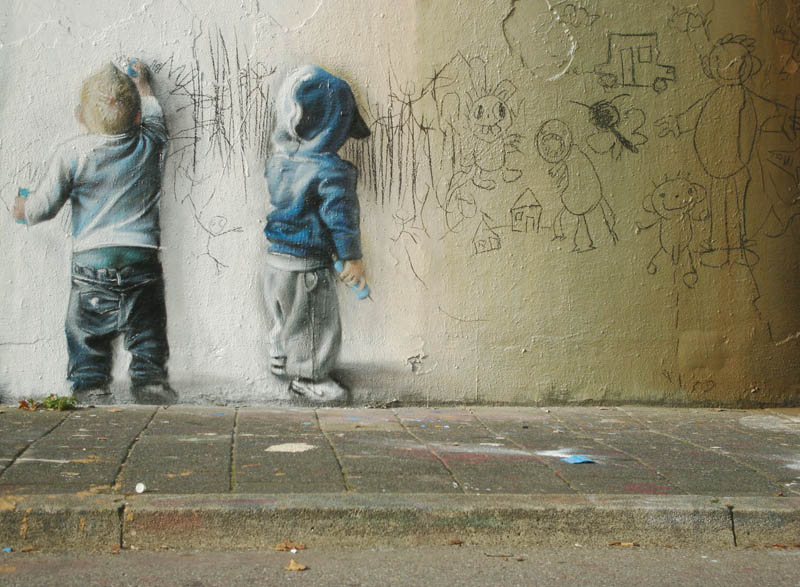 street art of two kids drawing scribbling on wall