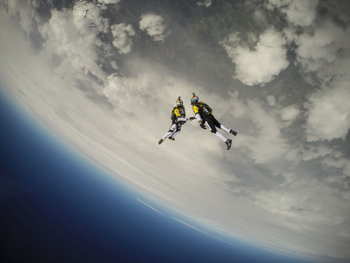 skydivers shaking hands mid-air