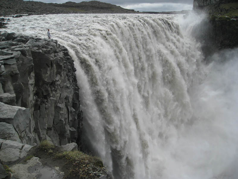 man standing next to Dettifoss waterfall in vatnajokull national park iceland the largest waterfall in europe