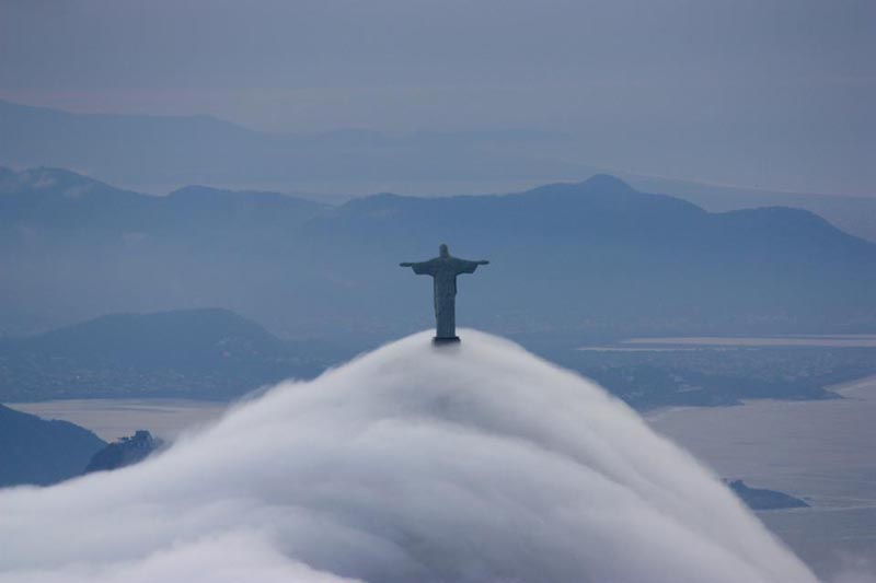 picture of clouds or heavy fog rolling past the feet of christ the redeemer statue in rio de janeiro brazil