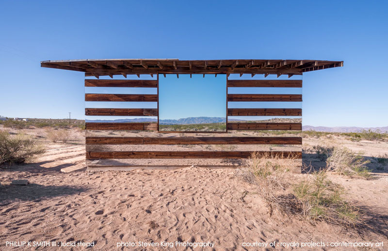 A Transparent Cabin of Wood and Mirrors on a Desert Landscape