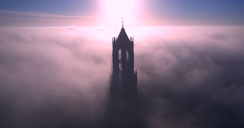 Drone Soars Above the Dom Tower of Utrecht on a Foggy Day
