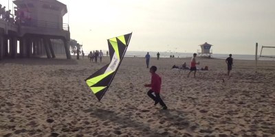 Amazing Kite Flyer Plays a Game of Tag with a Kid on the Beach