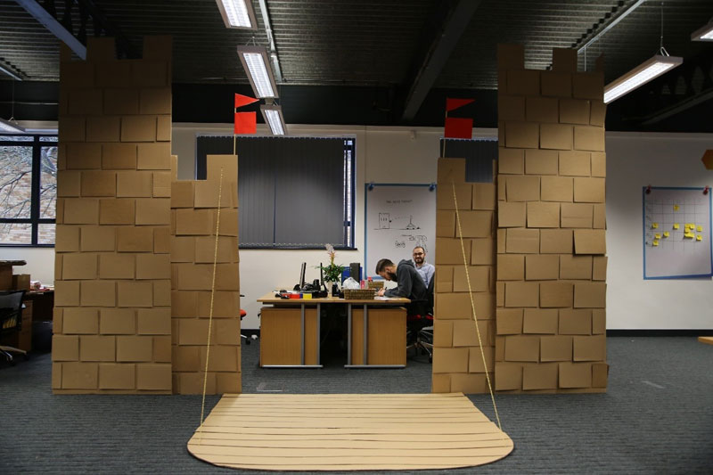 Boss Told Them to Jazz Up Their Cubicle So They Built a Cardboard Castle with Drawbridge