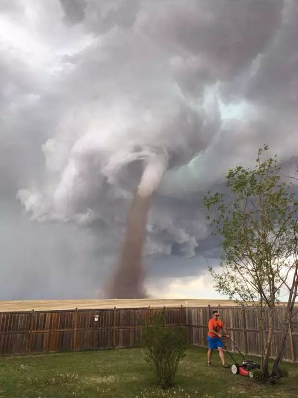 guy mowing lawn with tornado coming 1 When a Tornados Coming But Your Lawn is Life