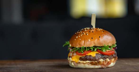A cheese burger on a board