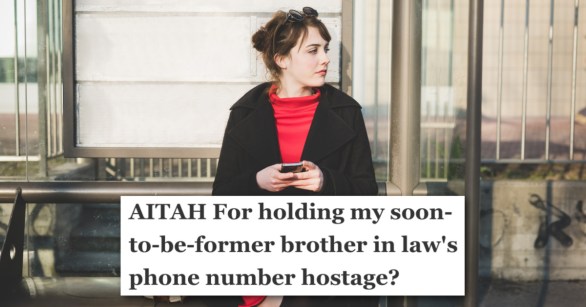 woman holding phone sitting at bus stop