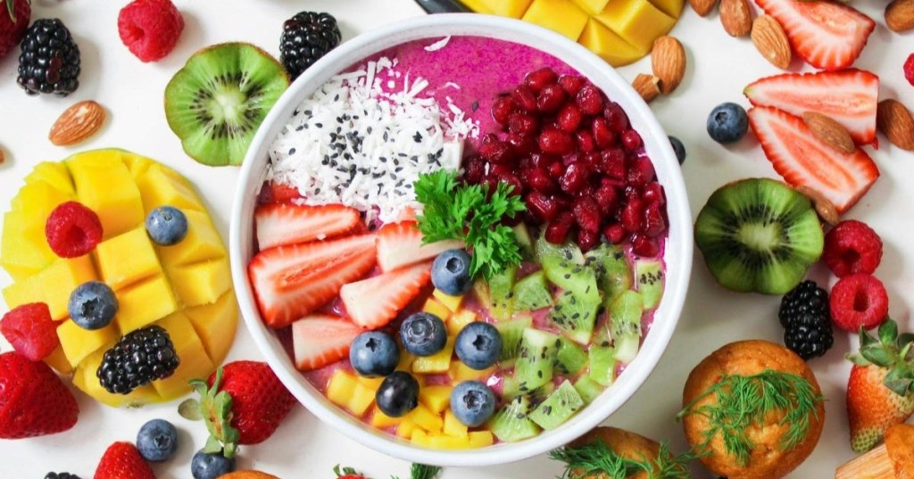 A smoothie bowl with fresh fruit and muffins