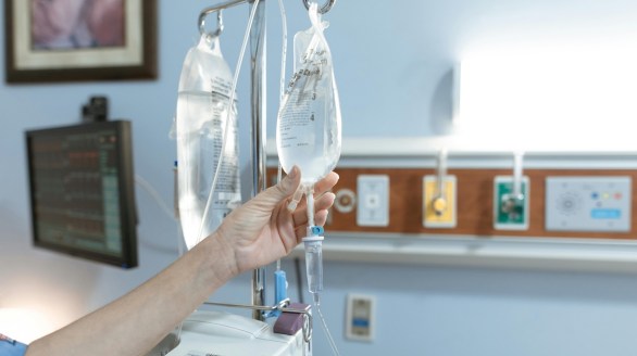 A nurse adjusting an IV drip bag