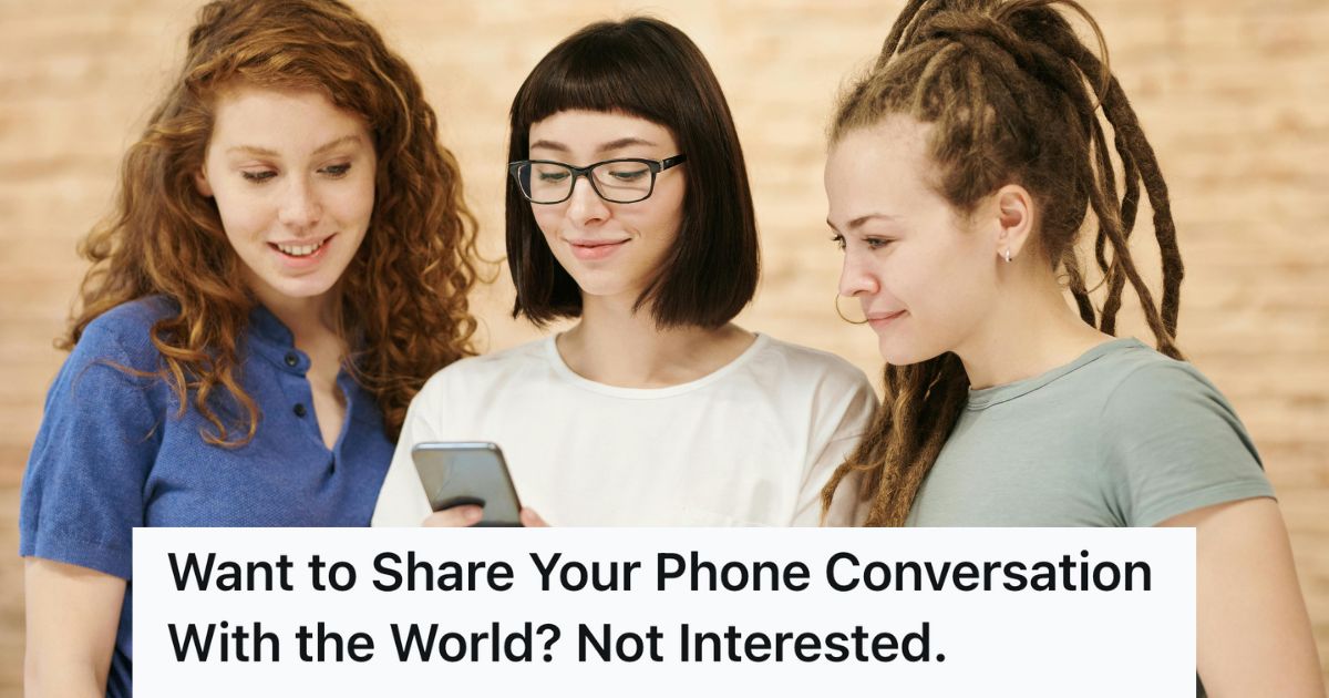 Three women look at a phone