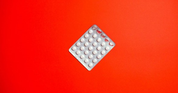 A blister pack of pills against a red background