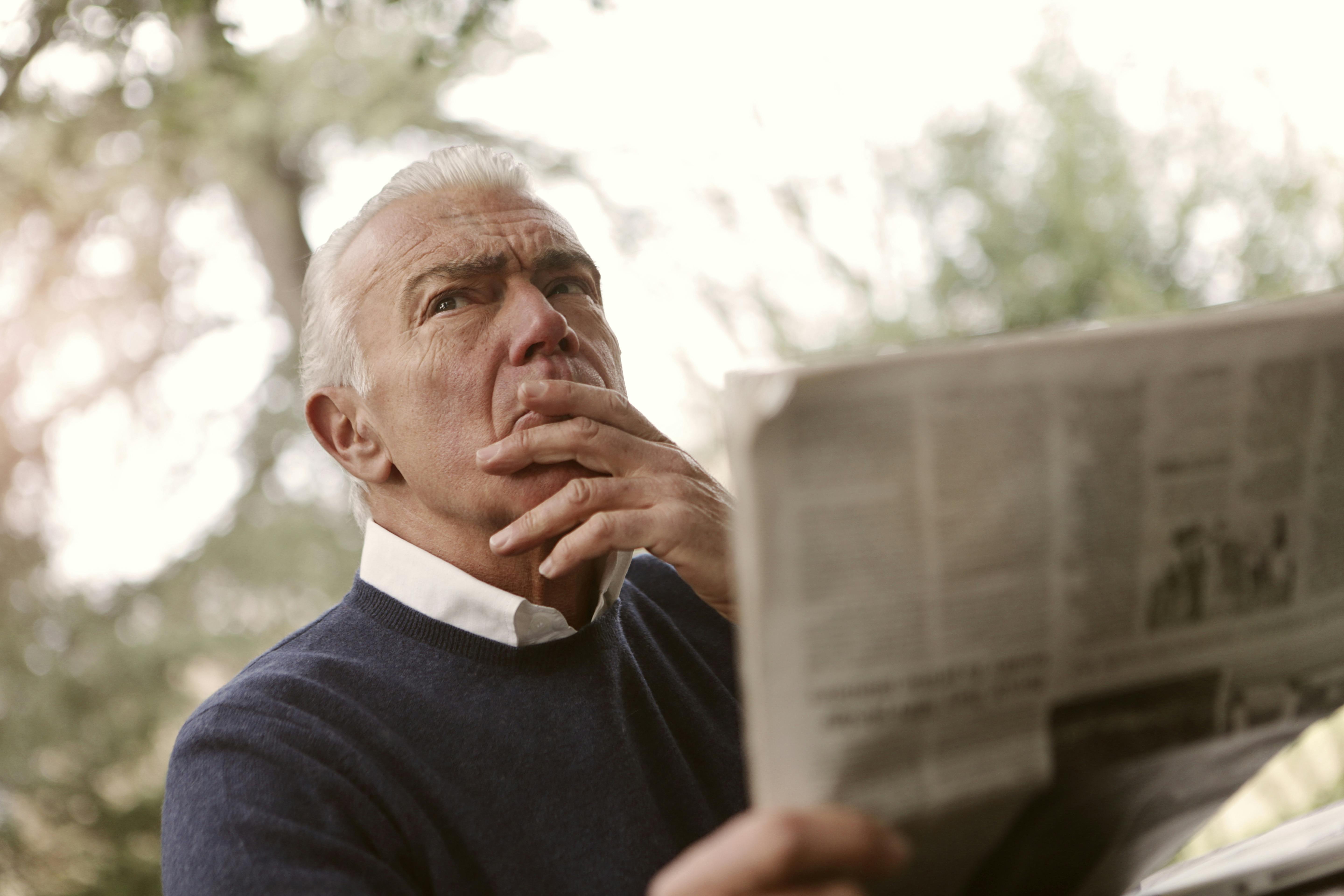 An older man reading a newspaper