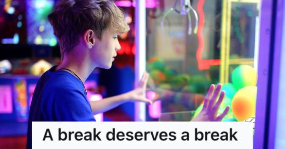 boy looking at a claw machine in the arcade