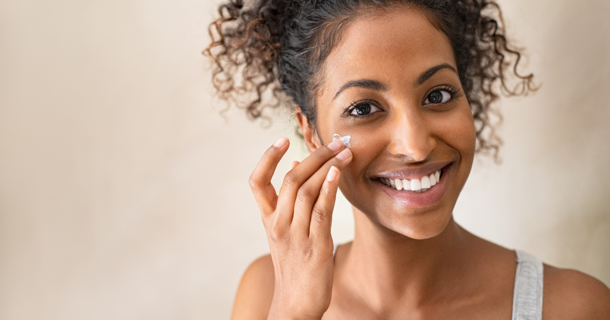 Attractive woman applying acne cream