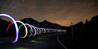 Swirling lights by a road against the night sky