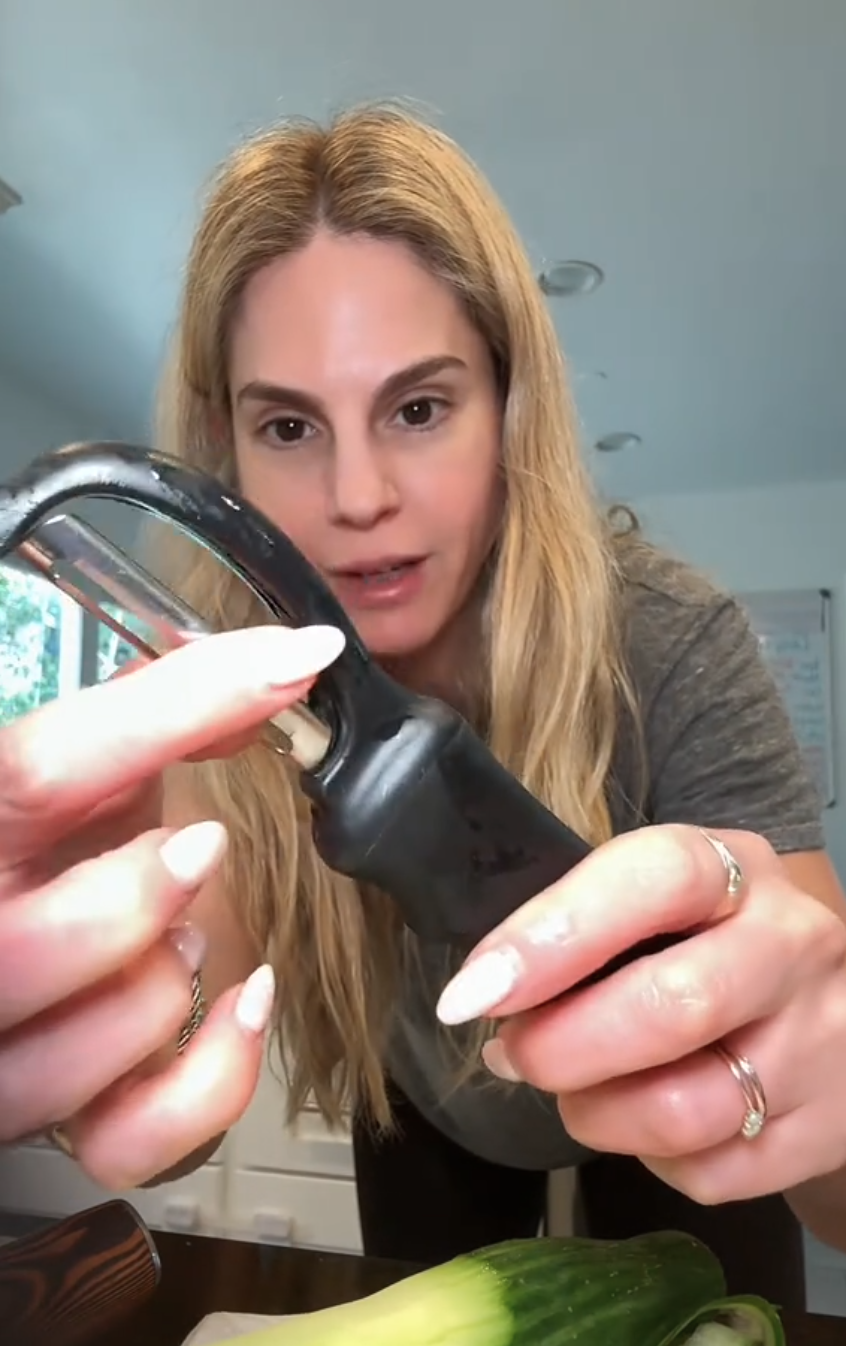 Woman peeling cucumber
