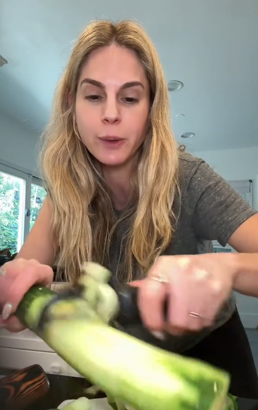 Woman peeling cucumber