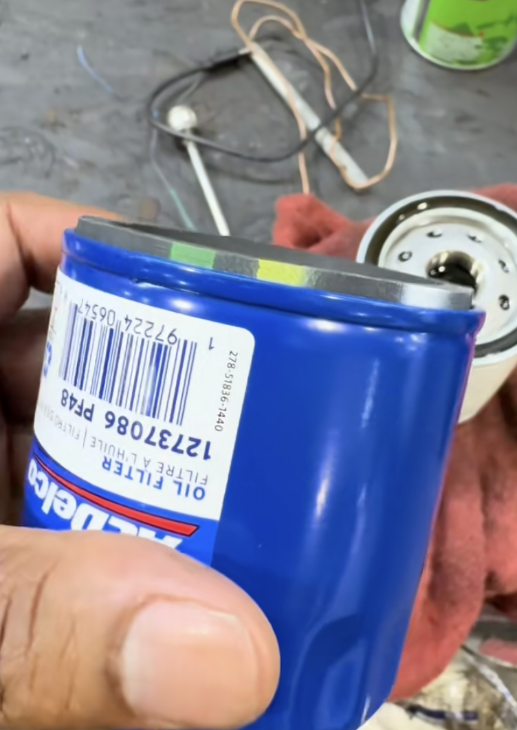 man holding blue oil can