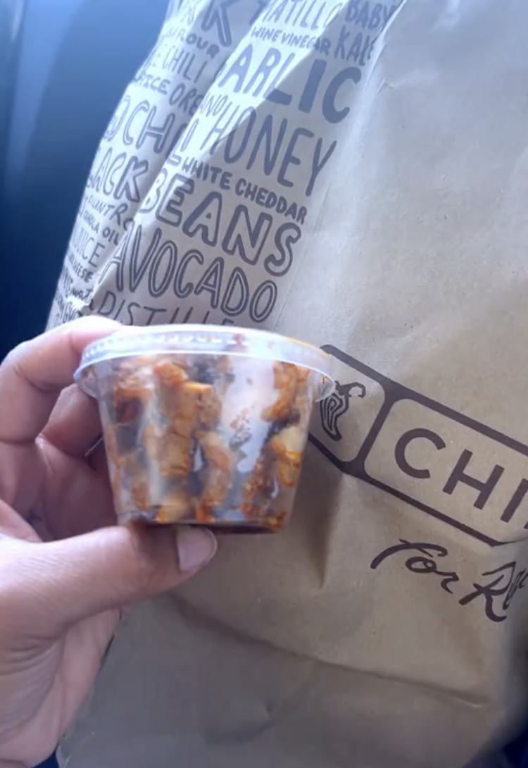 person holding container of chicken